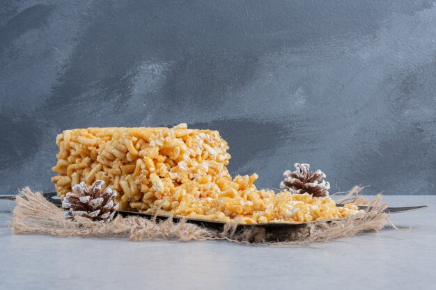 Splintered biscuit cake on an ornate tray on marble surface