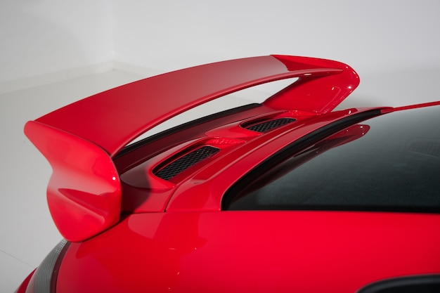 Spoiler of a red sports car in a white room