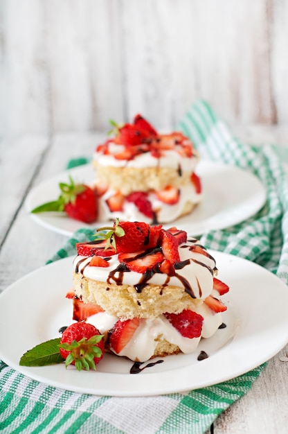 Free photo sponge cake with cream and strawberries