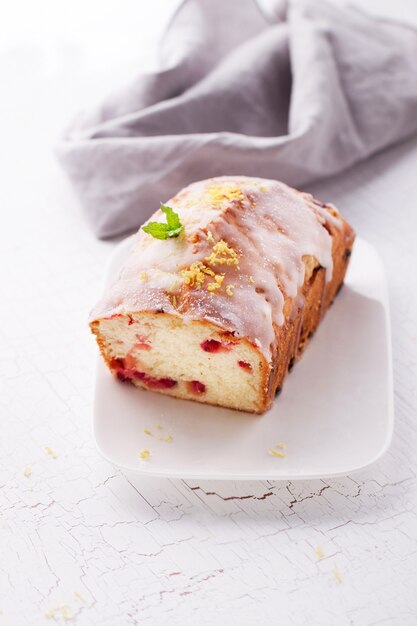Бисквитный торт с красными ягодами на тарелке