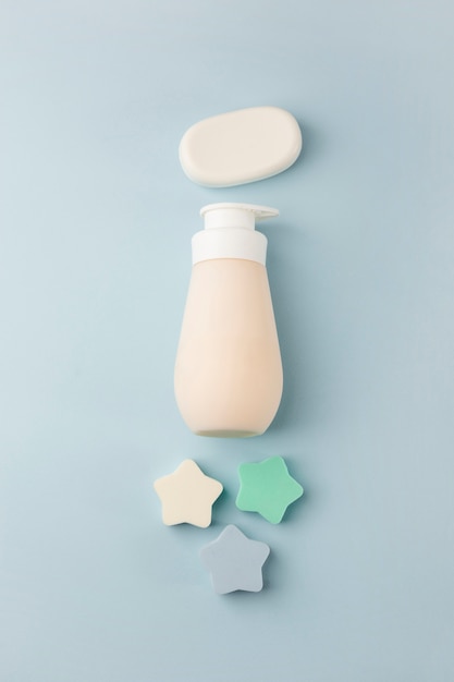 Free photo sponge stars; soap bar and dispenser on blue background