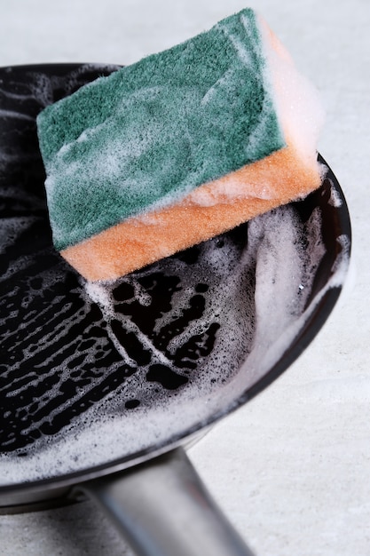 Sponge washing a pan