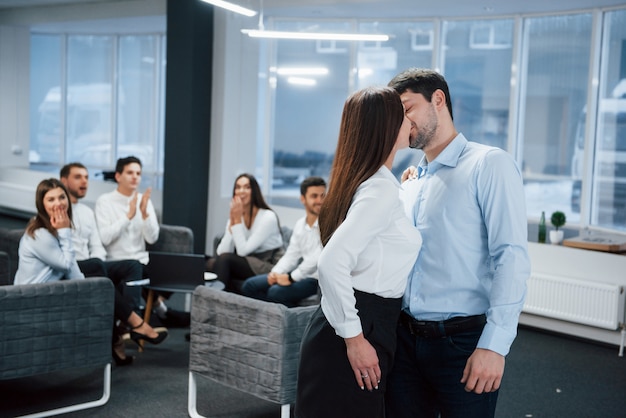 Spontaneous lovely kiss between two employees shocked other office workers