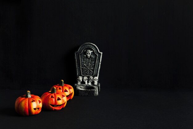 Spooky composition for halloween with tombstone and pumpkins