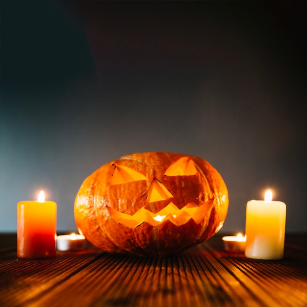 Spooky composition of pumpkin and candles