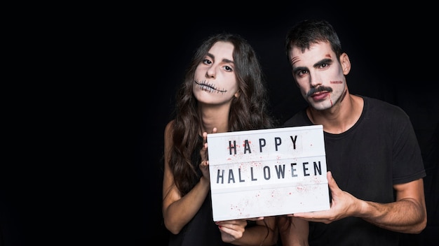 Free photo spooky friends holding signboard