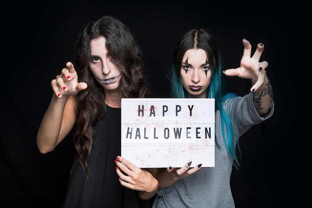 Spooky girls holding signboard