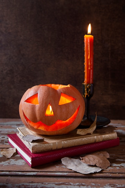 Foto gratuita lanterna di zucca intagliata spettrale di halloween con candelabri