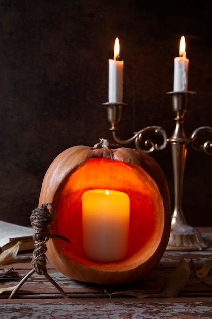 Foto gratuita lanterna di zucca intagliata spettrale di halloween con candelabri