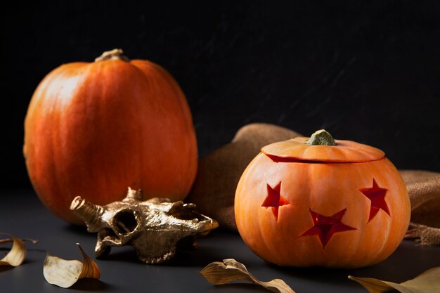 Spooky halloween carved pumpkin lantern with golden animal skull