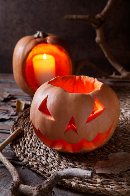 Free photo spooky halloween carved pumpkin lantern with lit candle