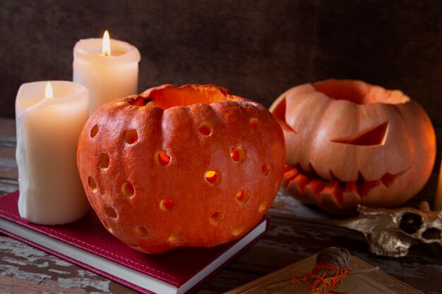 Free photo spooky halloween carved pumpkin lantern with lit candles