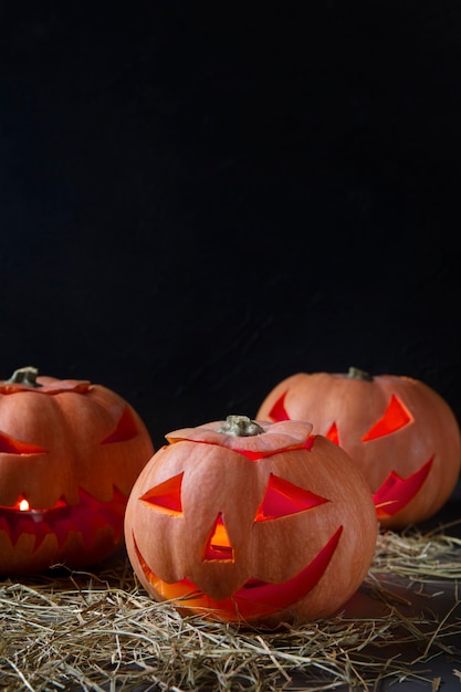 Free photo spooky halloween carved pumpkin lanterns with copy space