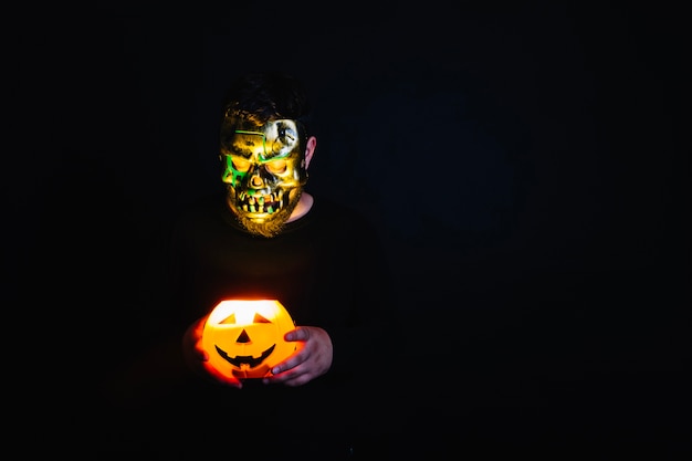 Free photo spooky man with burning halloween lantern