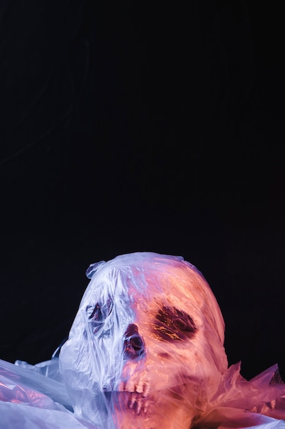 Spooky skull in plastic material illuminated by purple light