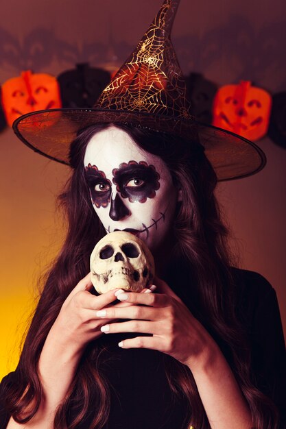 Spooky witch holding skull