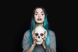 Free photo spooky woman holding human skull