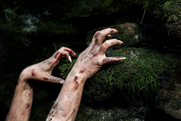 Foto gratuita mani spettrali di zombie in natura