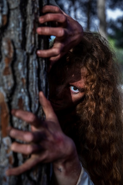 Foto gratuita mani spettrali di zombie su un albero