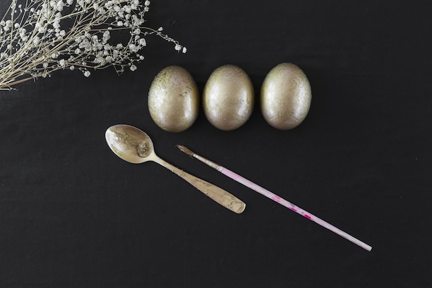 Foto gratuita cucchiaio e pennello vicino a uova di pasqua