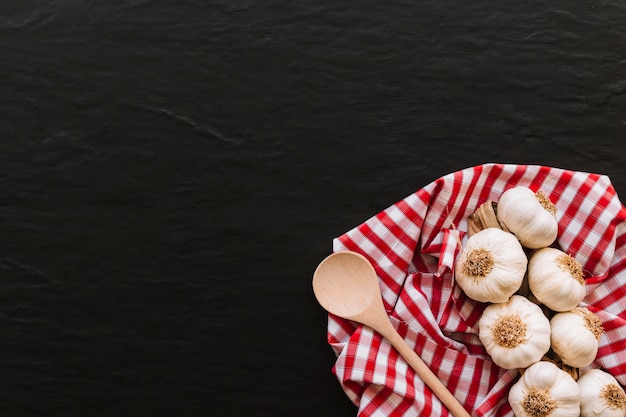 Spoon and garlic on napkin