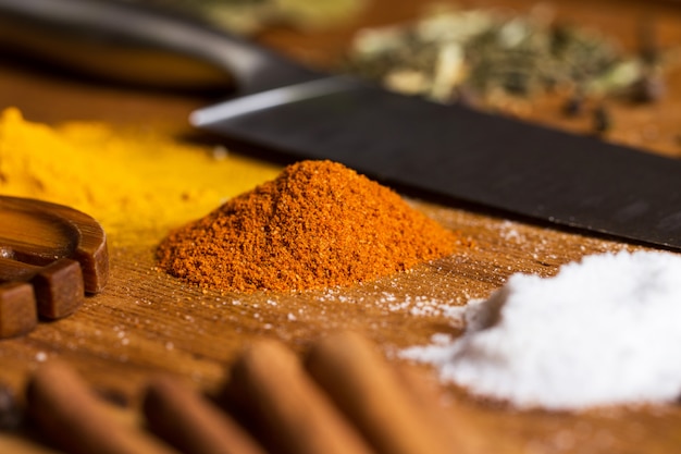 Spoon, knife and heap of spices on the table