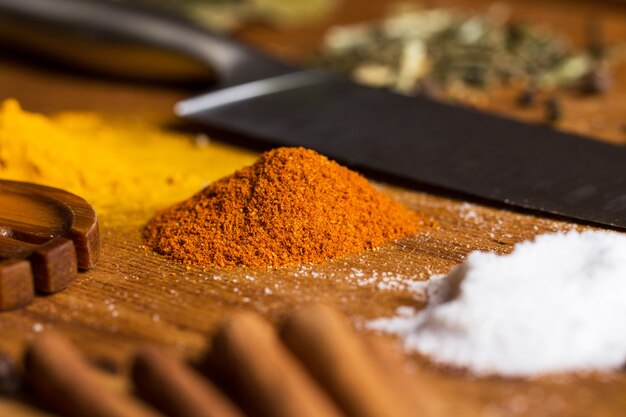 Spoon, knife and heap of spices on the table