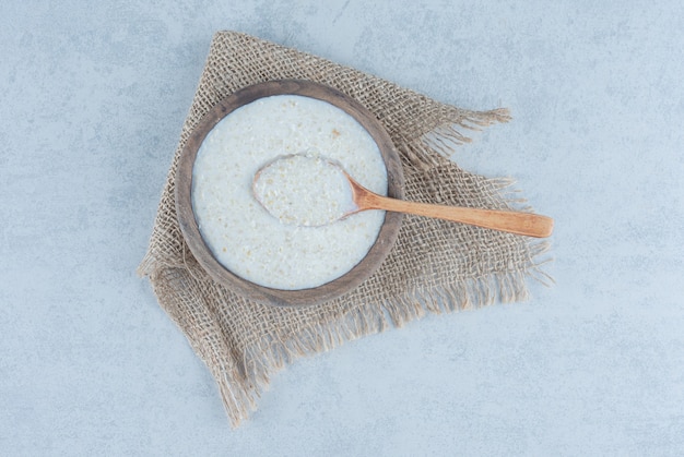 Spoon in rice bowl towel on marble.