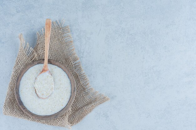 Spoon in rice bowl towel on marble.