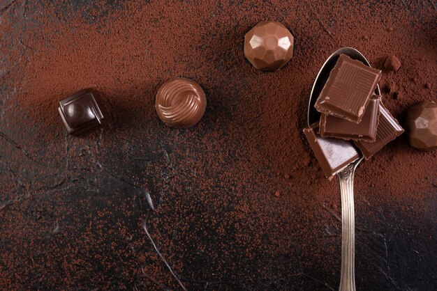 Spoon with chocolate bar squares and candies