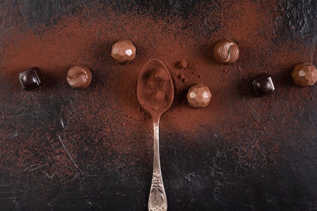 Spoon with chocolates and cocoa powder