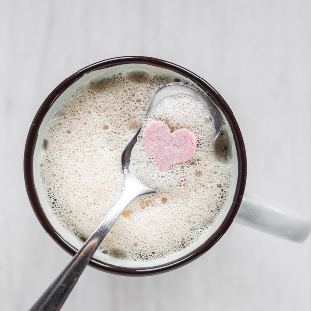 Spoon with heart in cup of coffee