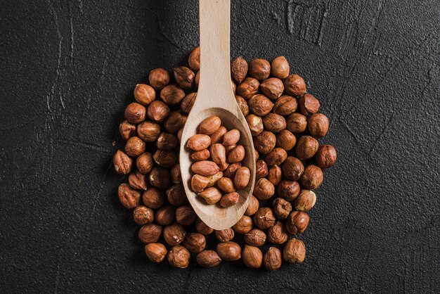 Free photo spoon with peanuts on hazelnuts