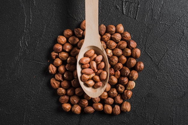 Spoon with peanuts on hazelnuts