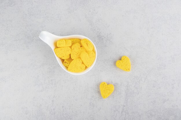 A spoonful yellow cookies on the blue surface