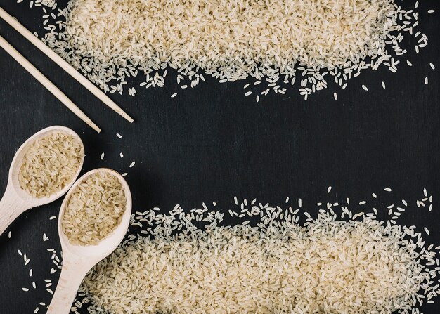 Spoons and chopsticks near heaps of rice