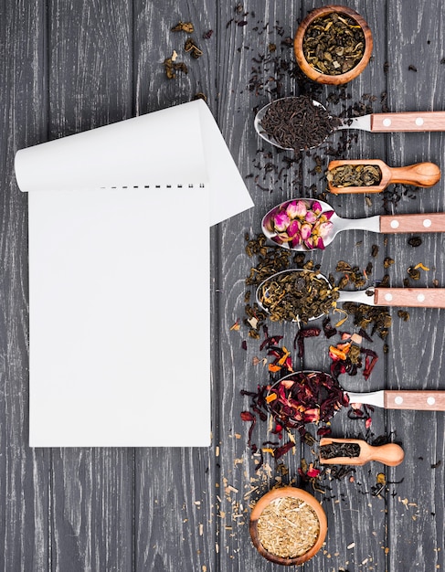 Free photo spoons with herbal tea beside notebook