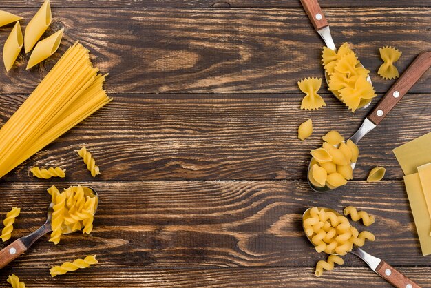 Spoons with pasta on table