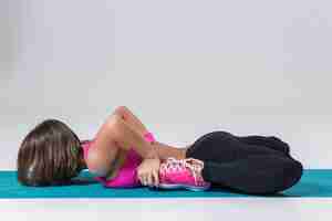 Free photo sport and active lifestyle. sporty flexible girl fitness woman in pink sportswear doing stretching exercise on light background.