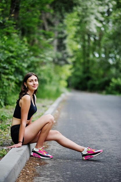 Sport girl at sportswear having rest in a green park after training at nature A healthy lifestyle