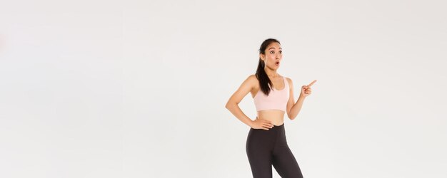 スポーツとジムのコンセプト フィットネス服 pointi で驚いて驚いたかわいいアジアの女の子の完全な長さ