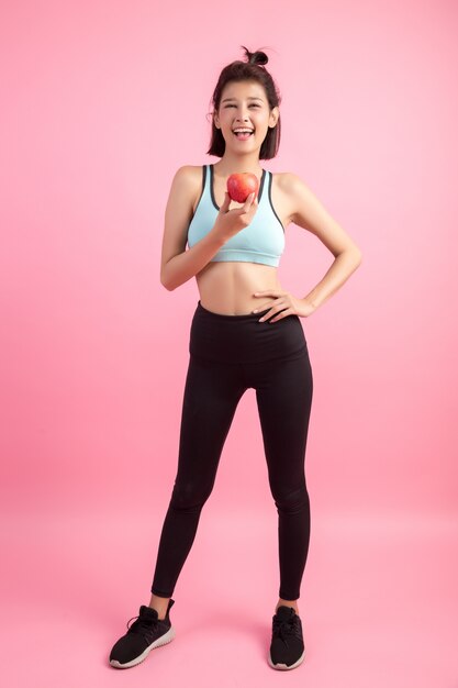 赤いリンゴを保持しているスポーツ健康的な女性