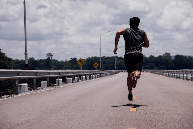 Lo sport uomo con corridore in strada correrà per l'esercizio