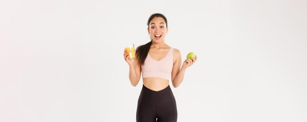 Sport wellbeing and active lifestyle concept excited cute asian fitness girl sportswoman with apple