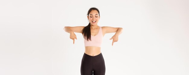 Sport wellbeing and active lifestyle concept excited and happy asian fitness girl in sportswear poin