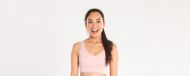 Sport wellbeing and active lifestyle concept happy smiling asian sportswoman in sportsbra looking am