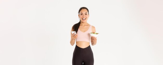 Sport wellbeing and active lifestyle concept smiling slim asian fitness girl in sportswear holding s