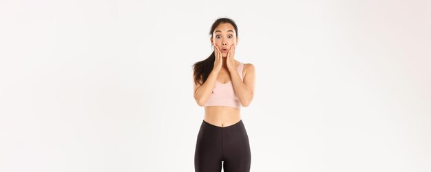 Sport wellbeing and active lifestyle concept surprised and amazed asian cute fitness girl looking at