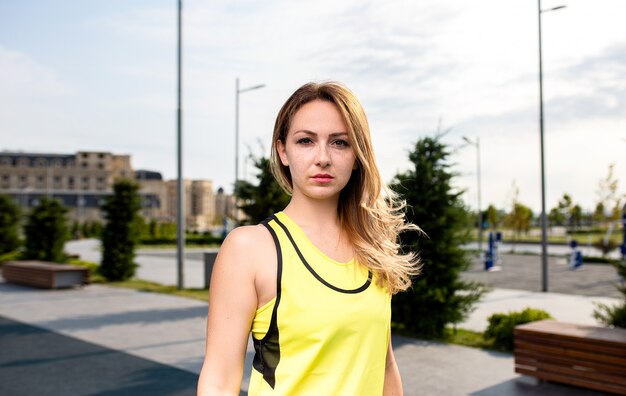 공원에서 노란색 복장에 스포츠 여자입니다.