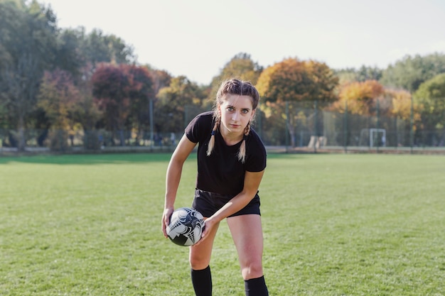 Sportive girl catching a rugby ball